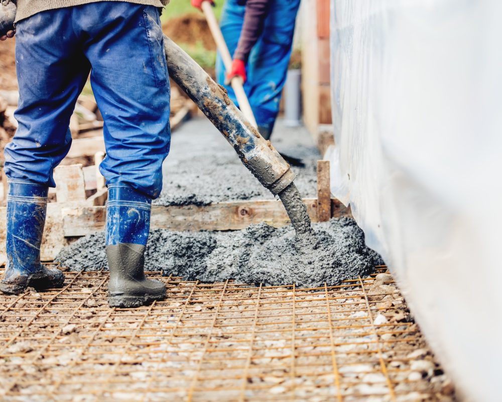 Constuction details - worker laying cement or concrete with automatic pump
