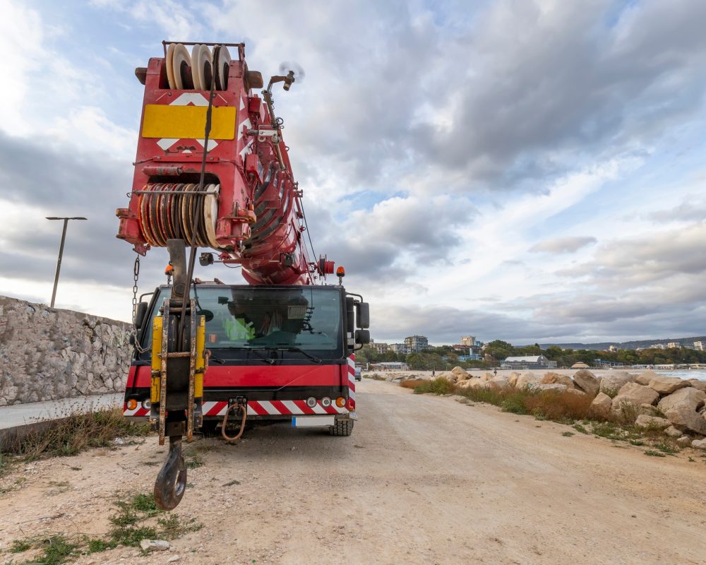 Heavy duty mobile crane parked near the sea. Telescopic truck mounted crane