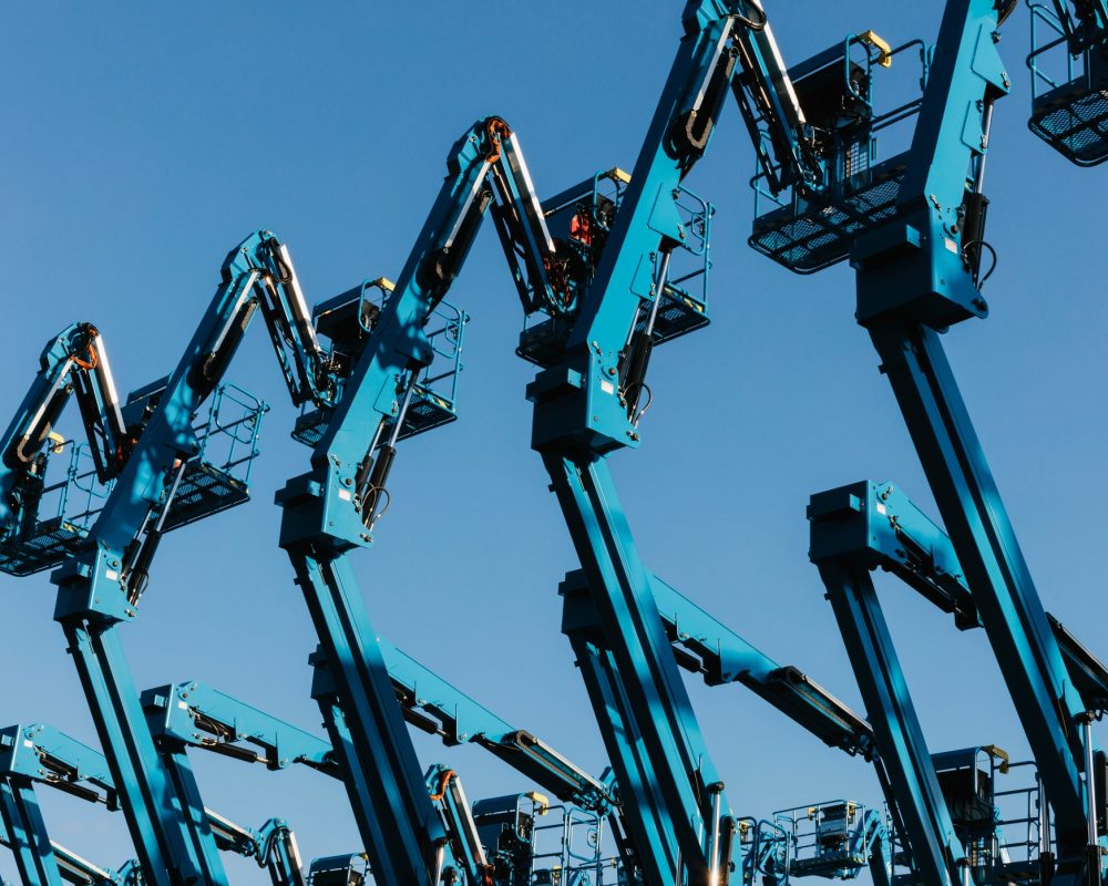 Row of hydraulic mobile cherry picker platforms at outdoor storage facility